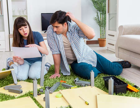 Young family assembling furniture at new house