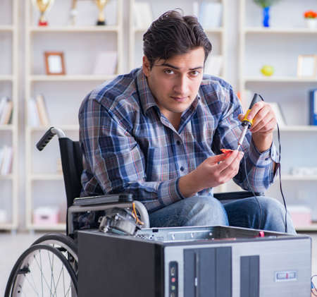 Computer repairman on wheelchair workingの写真素材