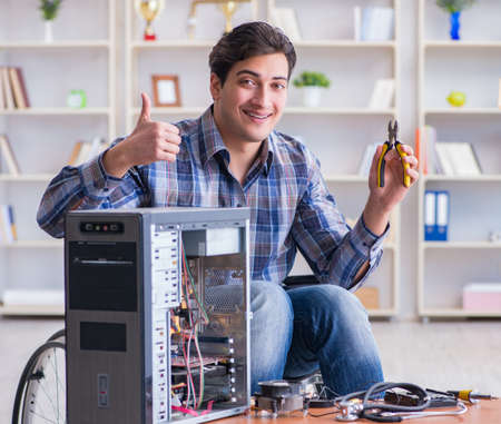 Disabled man on wheelchair repairing computer