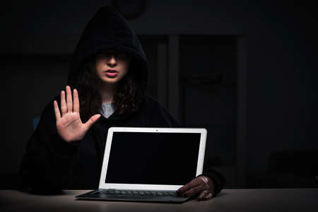 Female hacker hacking security firewall late in office