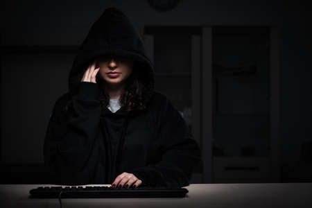 Female hacker hacking security firewall late in office