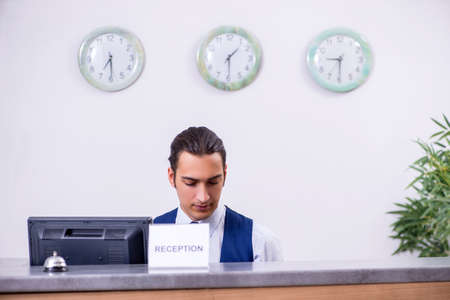Young man receptionist at the hotel counterの写真素材
