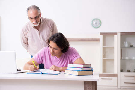 Old father helping his son in exam preparationの写真素材