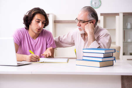 Old father helping his son in exam preparationの写真素材