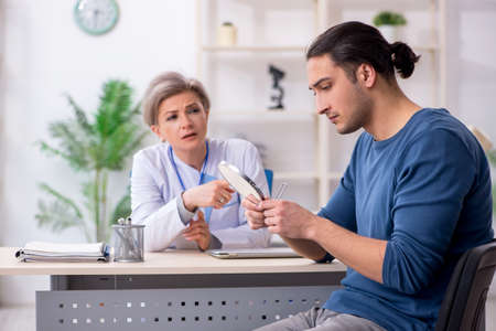 Young patient visiting doctor in hospitalの写真素材