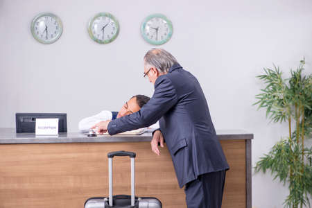 Old businessman at the hotel receptionの写真素材