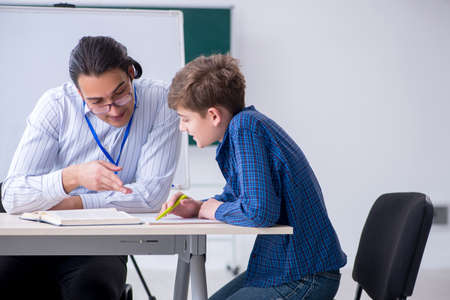 Young male teacher and boy in the classroom