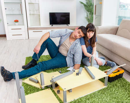 Young family assembling furniture at new houseの写真素材