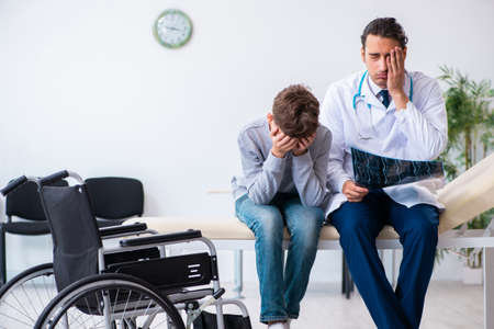 Young male doctor pediatrist and boy in wheel-chair