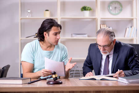 Young man visiting experienced male lawyerの写真素材