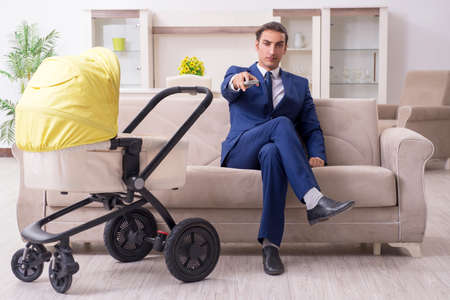 Young businessman looking after babyの写真素材