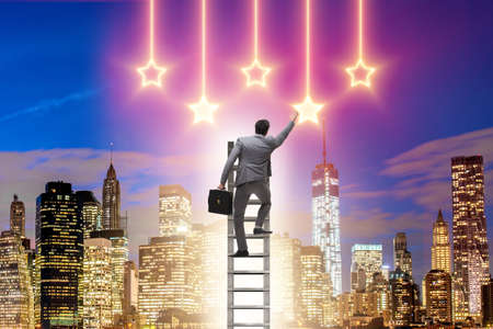Businessman reaching out for starsの写真素材