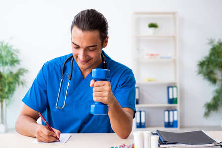 Young male doctor in sport and dieting conceptの写真素材