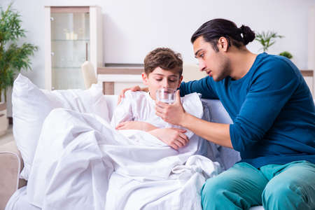 Young father caring for sick sonの写真素材