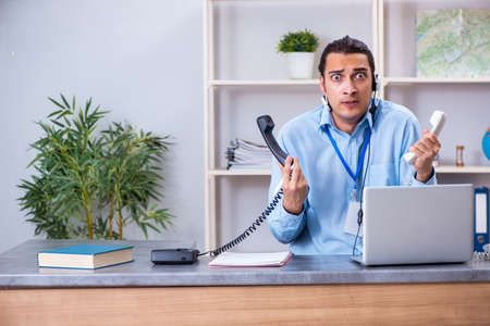 Young male travel agent working in the officeの写真素材
