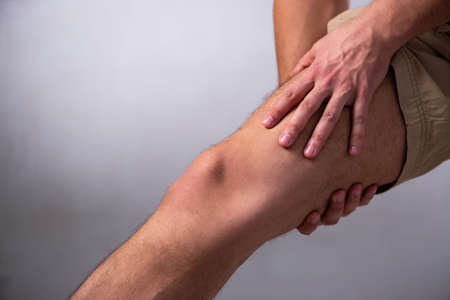 Young man suffering from leg painの写真素材