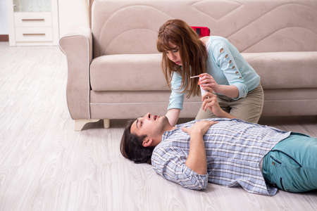 Young couple in first aid concept at home
