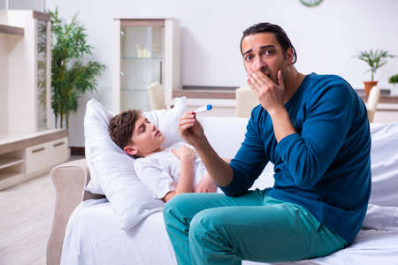 Young father caring for sick sonの写真素材
