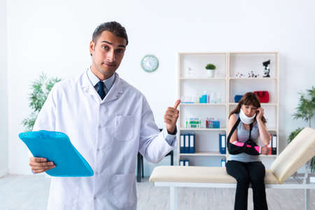 Young woman visiting male doctor traumatologistの写真素材