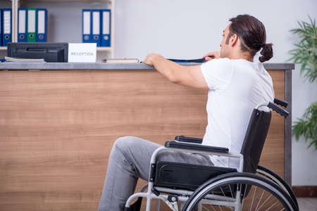 Young man at hospital reception deskの写真素材