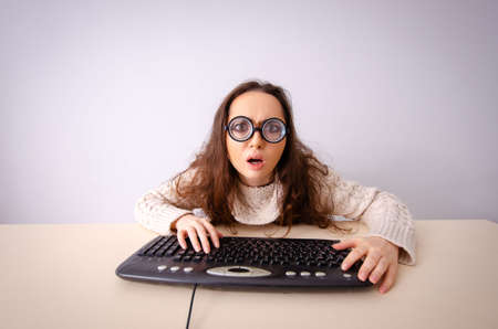 Funny nerd girl working on computerの写真素材