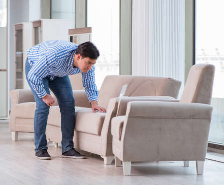 Young man shopping in furniture storeの写真素材