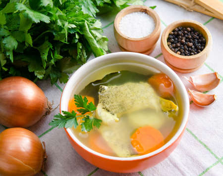 The fish soup served on the table in plateの写真素材
