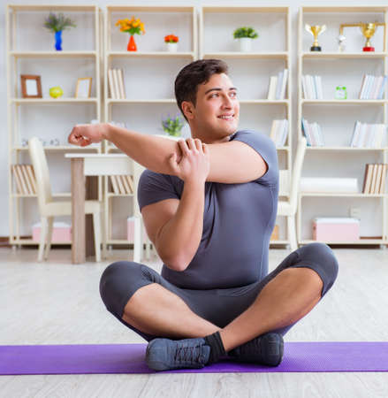 Young man exercising at home in sports and healthy lifestyle conの写真素材