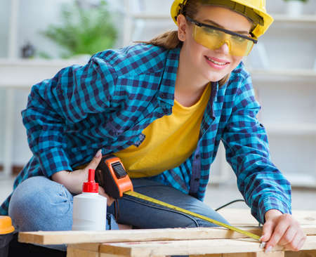 Female repairman carpenter cutting joining wooden planks doing rの写真素材