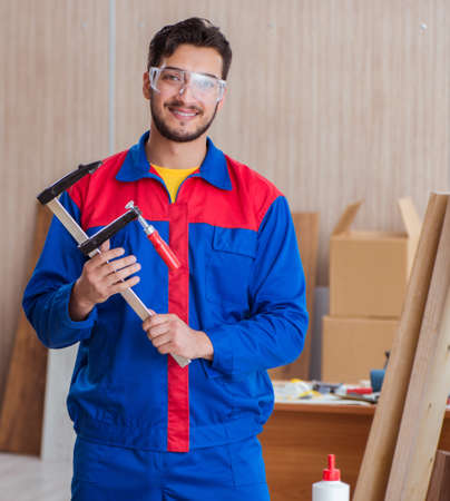 Young repairman carpenter working with clamps