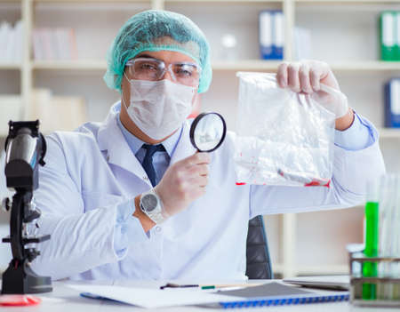 The forensics investigator working in lab on crime evidenceの写真素材