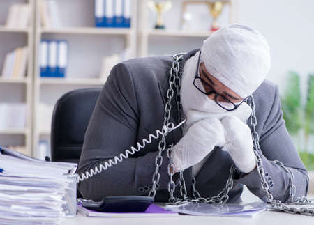 Bandaged businessman worker working in the office doing paperworの写真素材