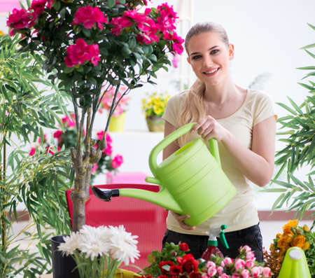 Young woman watering plants in her gardenの写真素材