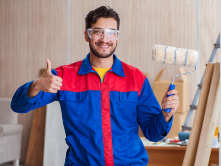 Yooung repairman carpenter working with paint paintingの写真素材