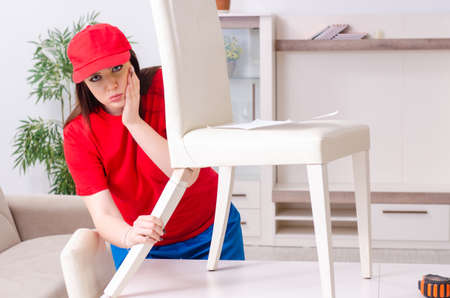 Young woman repairing chair at homeの写真素材