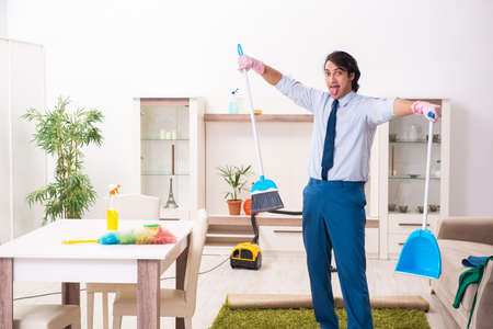 Young businessman cleaning the houseの写真素材