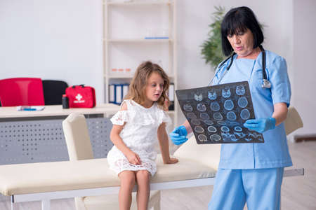 Little girl visiting old female doctorの写真素材