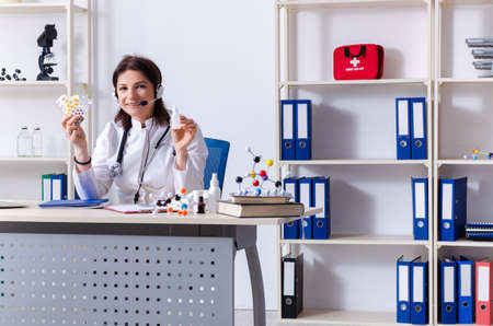 Middle-aged female doctor in telemedicine conceptの写真素材