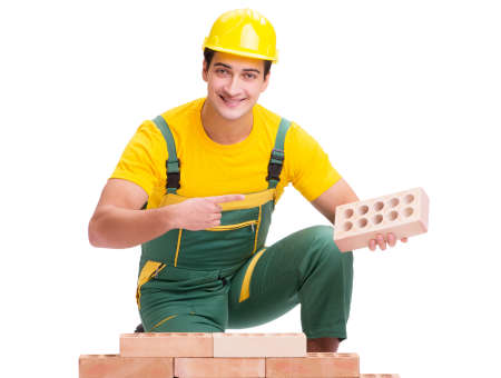 The handsome construction worker building brick wall