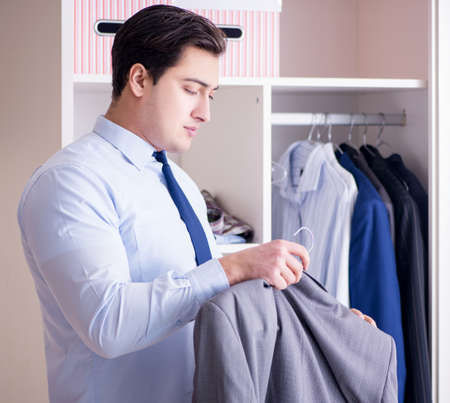 Young man businessman getting dressed for workの写真素材