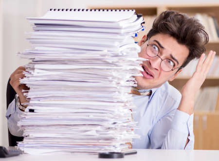 Mad businessman with piles of papers
