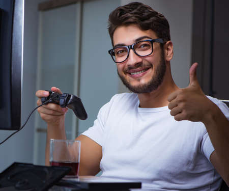 Young man playing games long hours late in the office