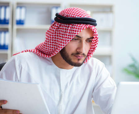 Arab businessman working in the office doing paperwork with a piの写真素材