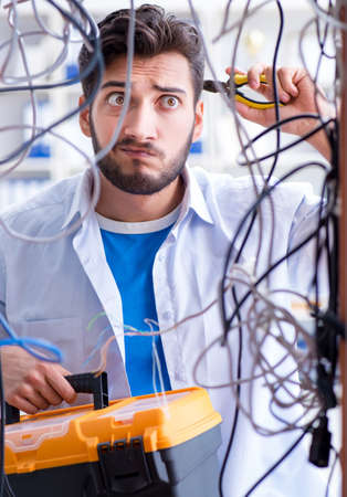 Electrician trying to untangle wires in repair conceptの写真素材