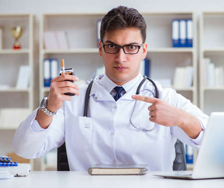 Male doctor in anti-smoking conceptwithcigarette packの写真素材