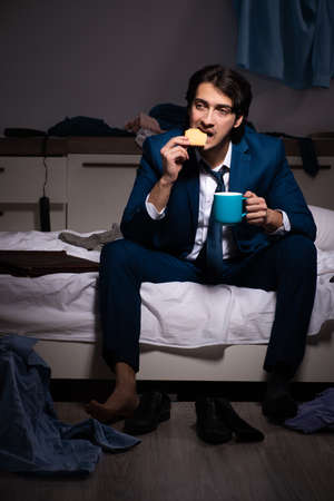Young employee working at home after night shiftの写真素材