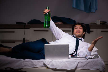 Young employee working at home after night shiftの写真素材