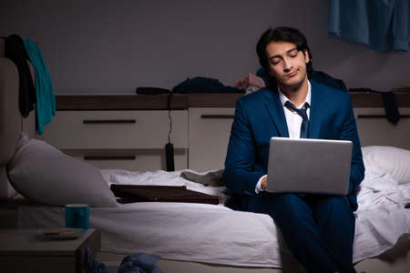 Young employee working at home after night shiftの写真素材