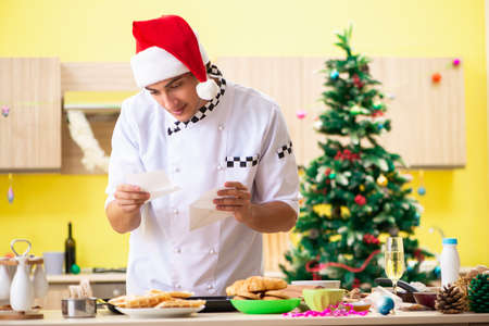 Young chef husband working in kitchen at Christmas eveの写真素材