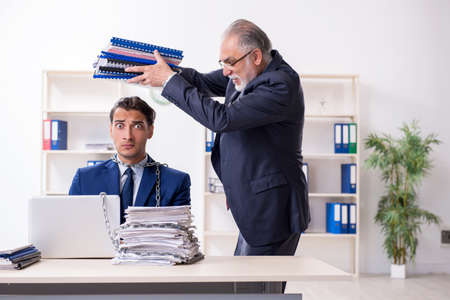 Old boss and young male employee in the officeの写真素材